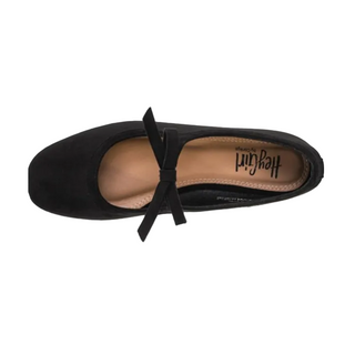 A single black ballet flat shoe with a bow detail across the instep, shown from a top-down view on a light gray background. The brand name 'Hey Girl by Ashley' is visible on the tan insole.