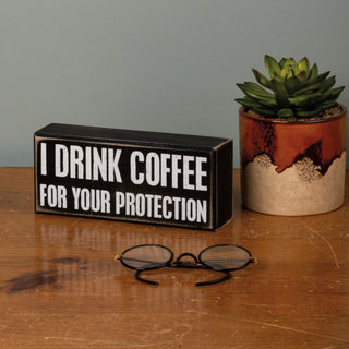 I Drink Coffee For Your Protection box sign angled view