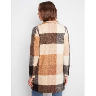 A woman shown from the back wearing a fuzzy, textured plaid cardigan with large checkered blocks of cream, tan, brown, and black, paired with blue jeans against a light gray background.