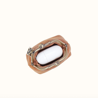 A top-down view of a small tan leather pouch with a silver metal kiss-lock closure, shown on a plain off-white background.