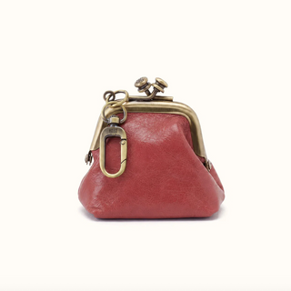 A small red leather kiss-lock coin purse with an antique brass metal frame and clasp, shown against a plain white background.