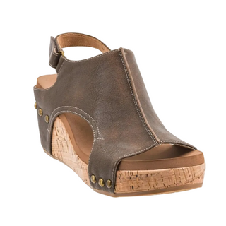 A single women's wedge sandal in distressed brown faux leather with a cork-textured wedge heel and gold-tone metal studs, shown against a plain white background.