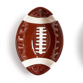 A glossy ceramic football-shaped dish or bowl in brown and white, featuring embossed laces and textured side details, shown on a white background.