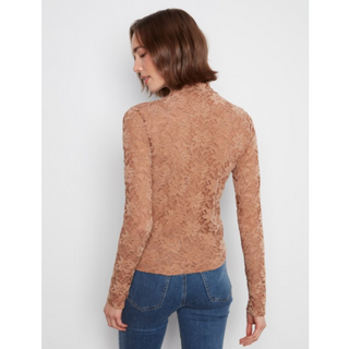 A woman shown from the back wearing a fitted, long-sleeve lace top in a warm tan/caramel shade, paired with blue jeans, against a plain light gray studio background.