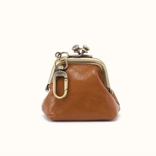 A small tan leather kiss-lock coin purse with antique brass hardware, shown on a plain white background.