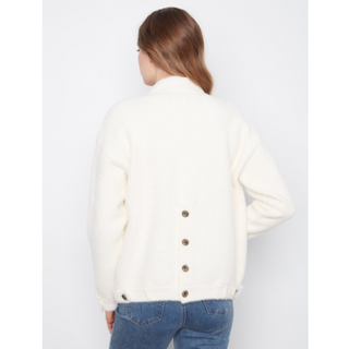 A woman viewed from the back wearing a cream-colored jacket with a row of silver buttons down the center, paired with blue jeans, against a plain light gray background.