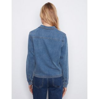 A woman viewed from the back wearing a medium-wash blue denim shirt and dark blue jeans against a light gray studio background.
