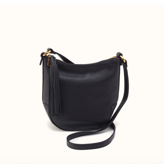 A black pebbled leather shoulder bag with a tassel zipper pull and gold-tone hardware, shown on a clean off-white background.