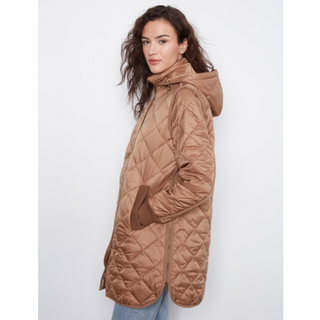 A woman wearing a long quilted puffer coat in a warm camel brown color, shown from a side profile against a light gray studio background.