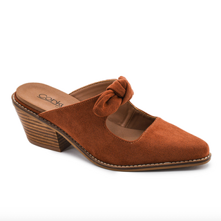 A women's mule sandal in rust-brown suede with a pointed toe, low stacked block heel, and a knotted bow detail across the instep. The shoe is photographed from a side angle on a clean white background.