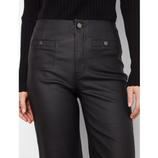 Close-up of a person wearing black high-waisted pants with a smooth leather-like finish, shown from the waist down against a light gray studio background.